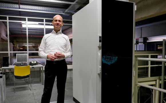 Geschäftsführer Peter Benthues neben dem "Gehirn" der AutoStore Anlage