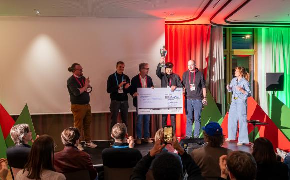 Pokal und Scheckübergabe an Gewinner-Team SaniUp aus Münster (v.l.n.r.: Stephan Egbringhoff (AKEYI), Max Winter (SaniUp), Christoph Büth (NRW.BANK), Tim Rothenpieler (SaniUp), Jens Hauser (SaniUp) und Linda Witzel (Moderatorin)